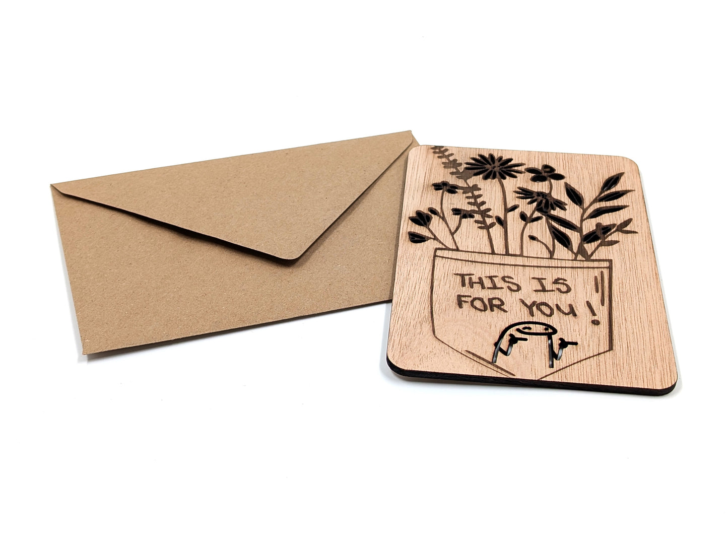 Handgemaakte houten kaart met bloemenontwerp en tekst naast een duurzame bruine envelop.
