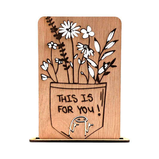 Houten wenskaart met een gravure van een pot vol bloemen en de tekst 'THIS IS FOR YOU!' met een klein cartoonfiguurtje.