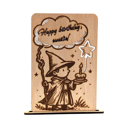 Houten kinderverjaardagskaart met gravure van een kleine tovenaar met taart en de tekst 'Happy birthday sweetie!' in een wolk.